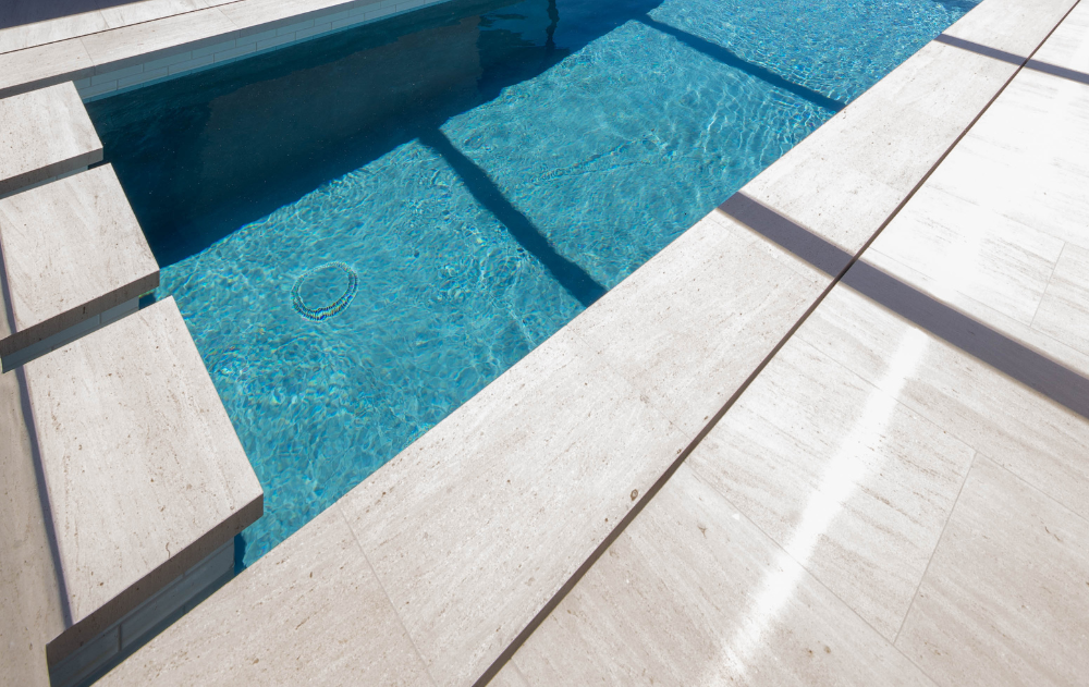 Large-format porcelain tile installed around a luxury Southern California pool deck.
