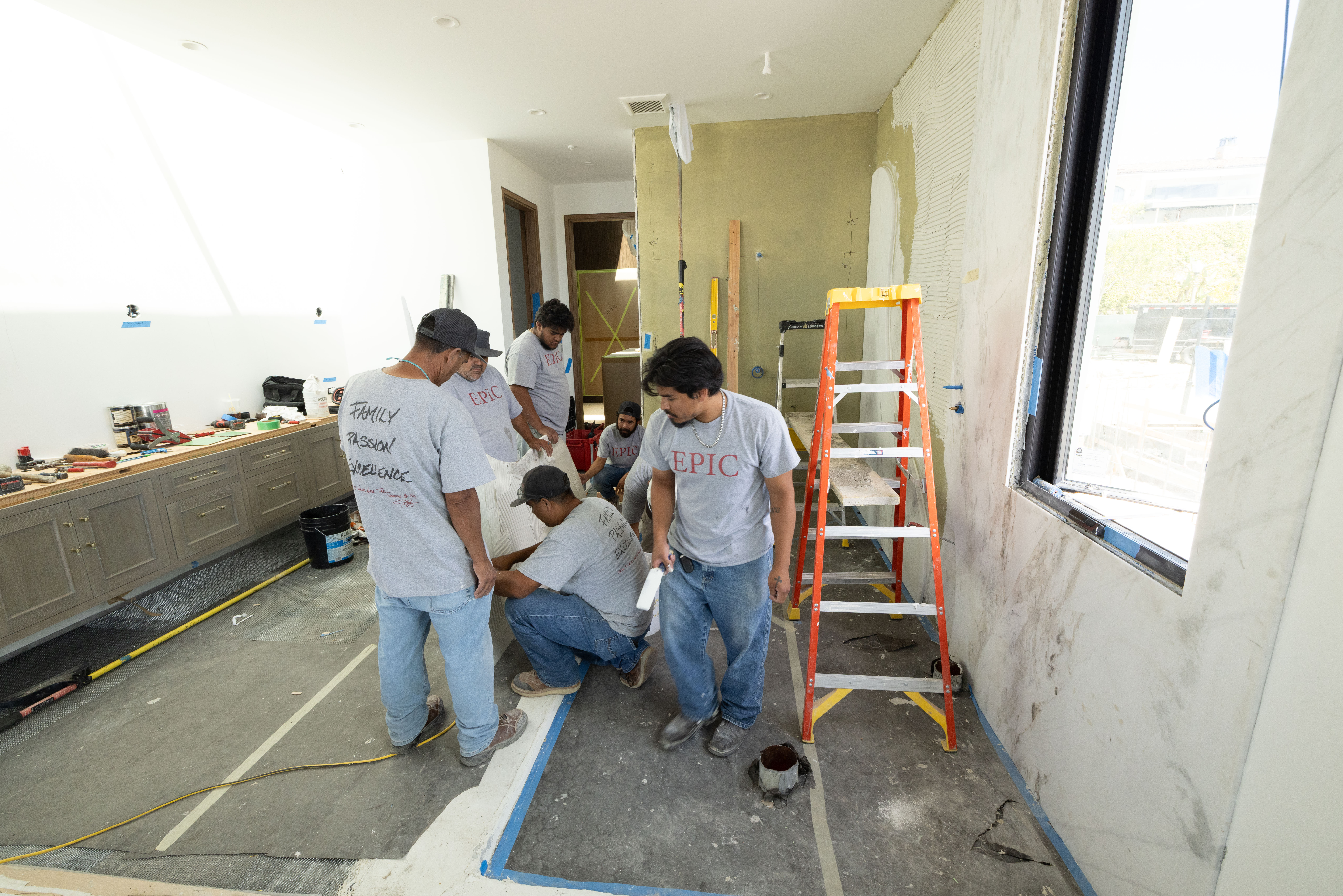 Epic Ceramic & Stone team measuring and planning a luxury residential stone installation project in Orange County.